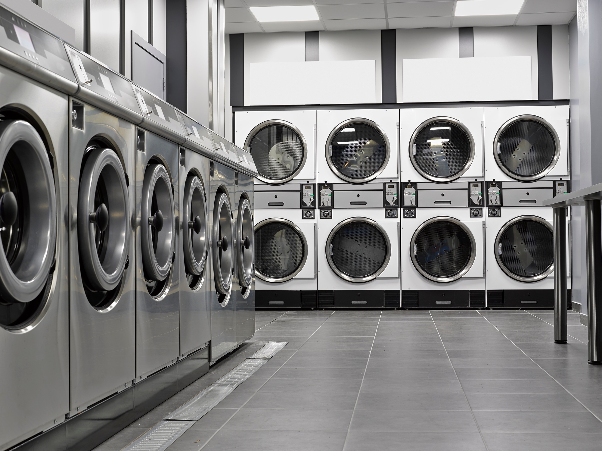 Row of industrial washing machines in a public laundromat